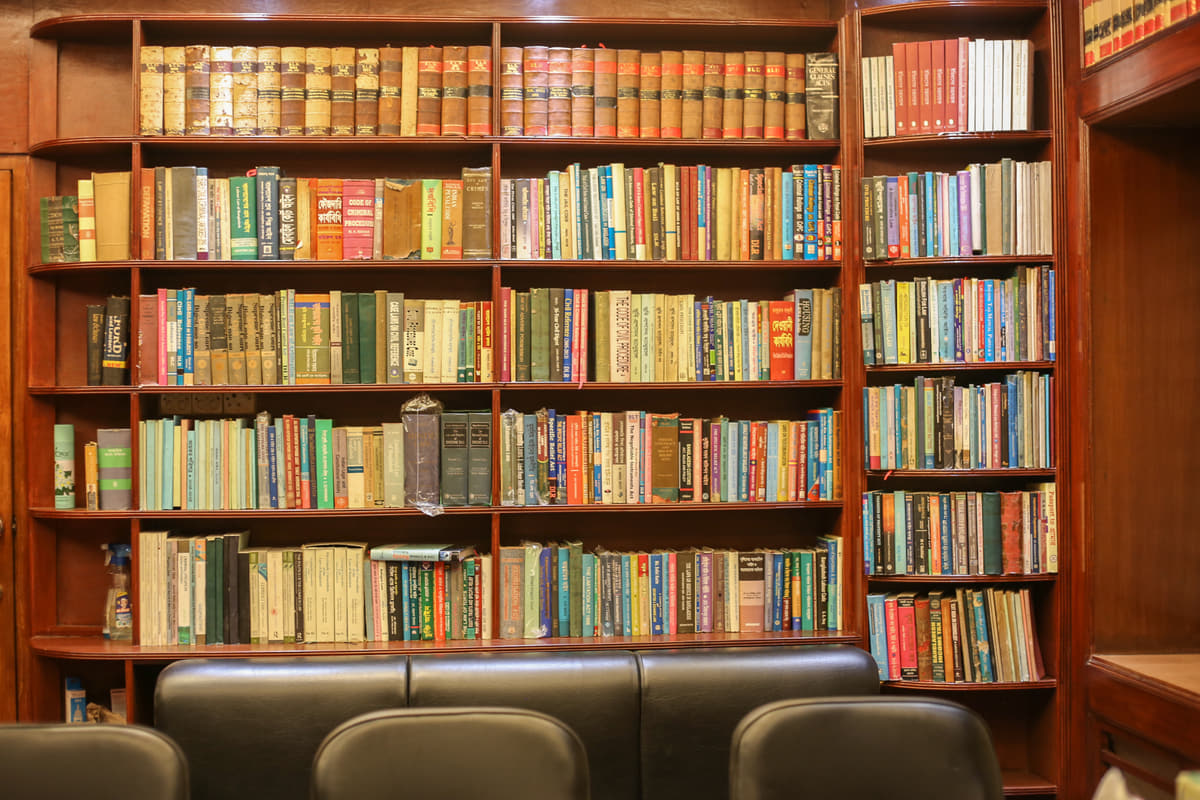 A wall of the chambers’ library: bound law reports along the upper shelves, statutes and reference works below, seating beneath them.