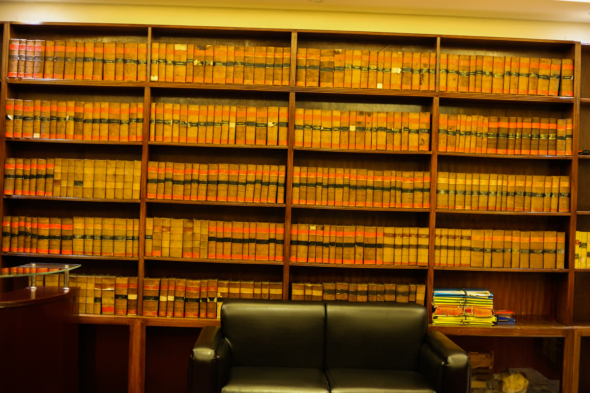 The chambers’ run of bound law reports, shelf upon shelf, above a settee and the reception desk.