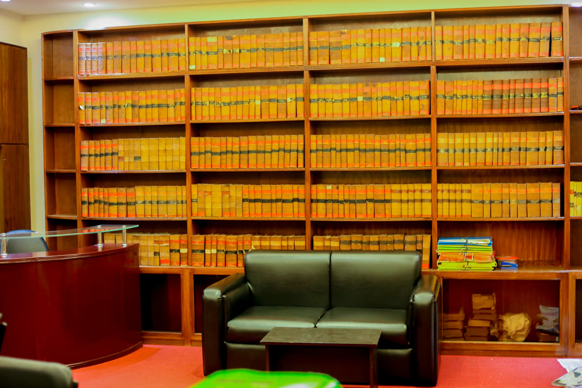 The same library from further back, the bound reports filling the wall above the settee and the reception desk.