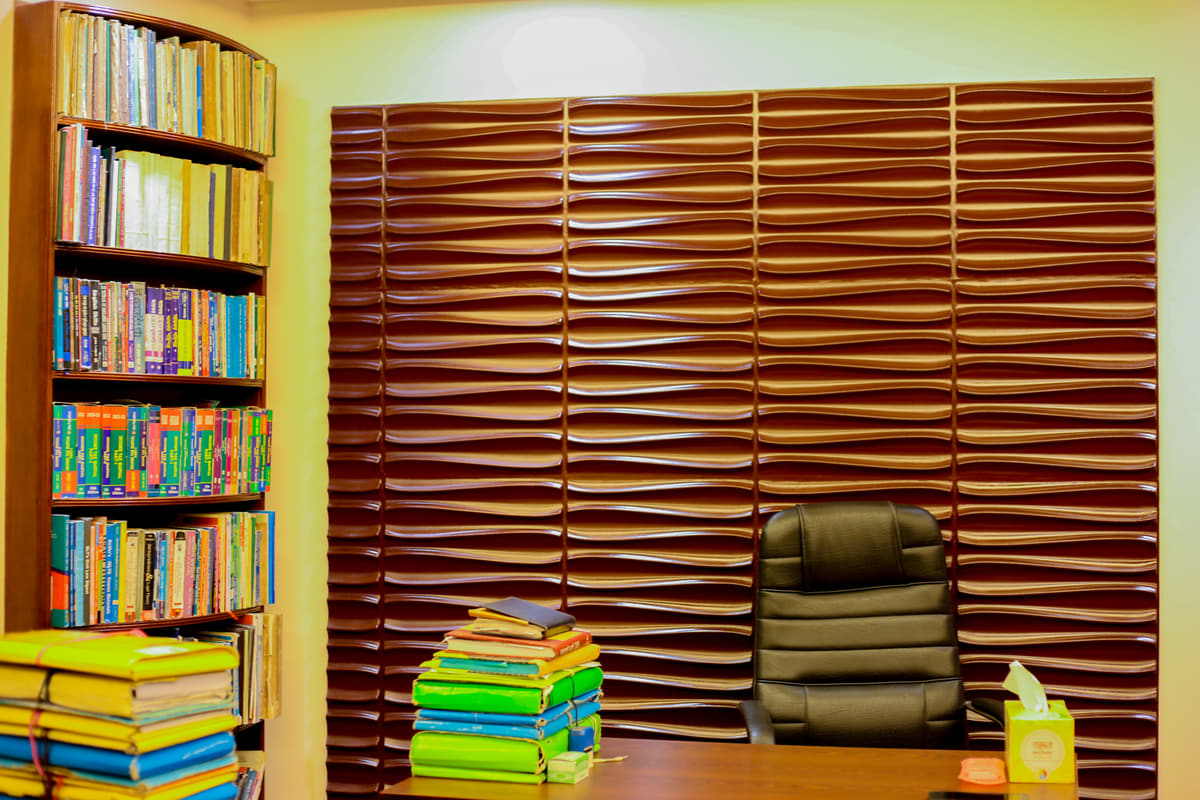 A consulting room in the chambers: a panelled wall behind the desk, a bookcase beside it, tied bundles of case files stacked alongside.